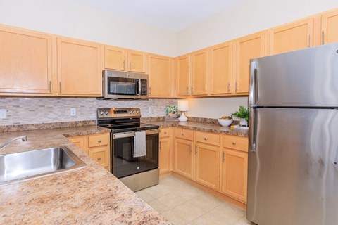 A kitchen with wooden cabinets and granite countertops.