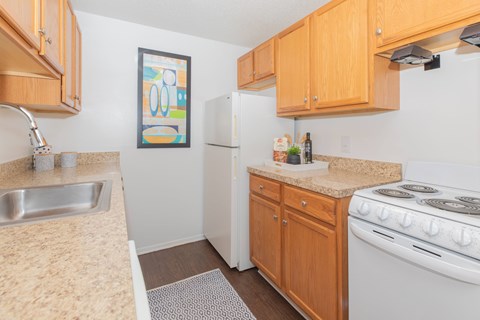A kitchen with a white stove and wooden cabinets.