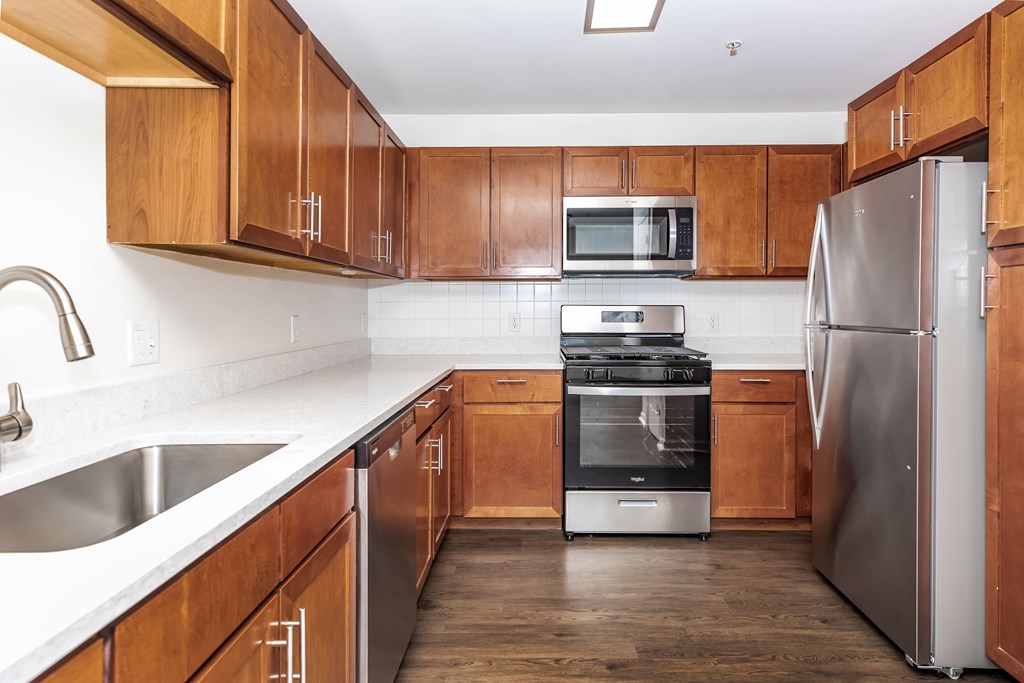 A kitchen with wooden cabinets and stainless steel appliances.