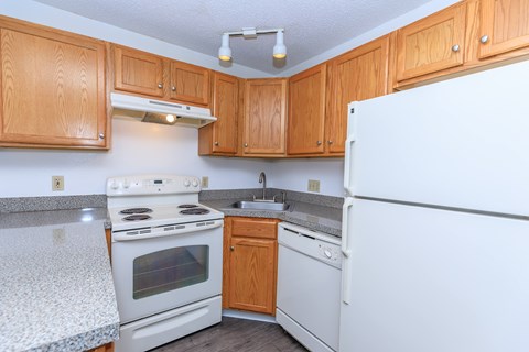 A kitchen with wooden cabinets and white appliances.