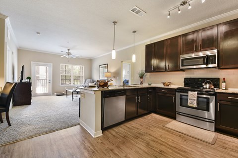 A kitchen with dark brown cabinets and stainless steel appliances.