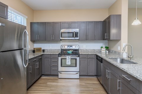 A kitchen with a stainless steel refrigerator and a stainless steel oven.