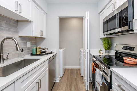 A kitchen with white cabinets and a black stove top.