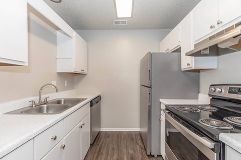 A kitchen with white cabinets and stainless steel appliances.
