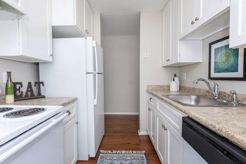 A kitchen with white cabinets and a black dishwasher.