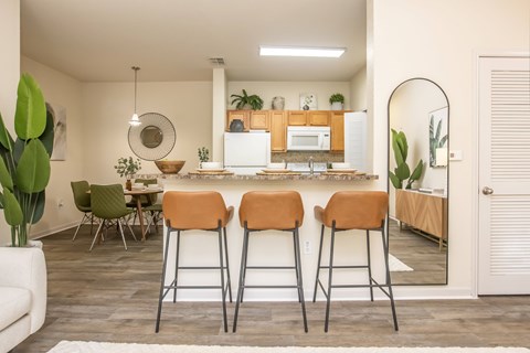 A kitchen with a bar stool in front of it.
