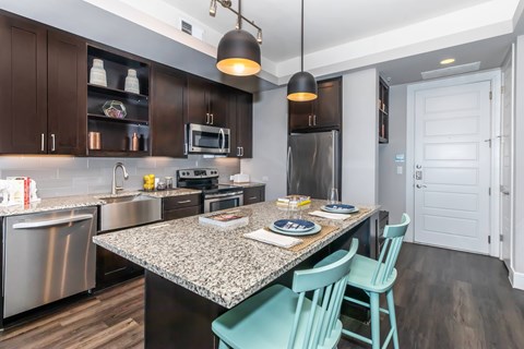 A kitchen with a table and chairs.