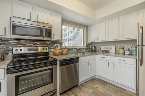 A kitchen with white cabinets and stainless steel appliances.