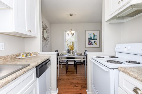 A kitchen with white cabinets and a large island with a marble countertop.