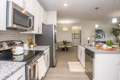 A kitchen with a refrigerator, stove, and microwave.