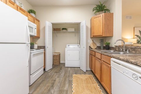 A kitchen with white appliances and wooden cabinets.