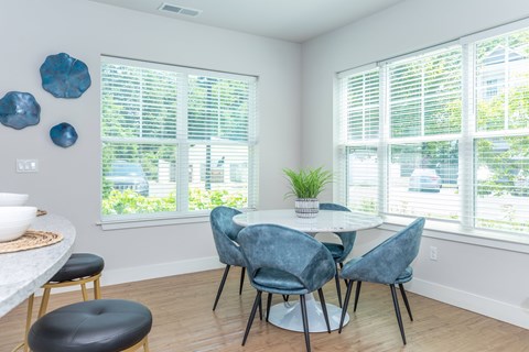 A dining room with a white table and blue chairs.