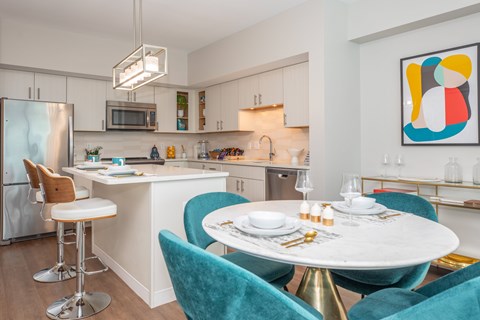 A modern kitchen with a dining table set for two.