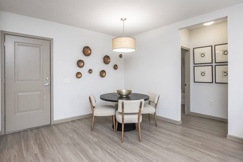 A dining room with a round table and chairs.