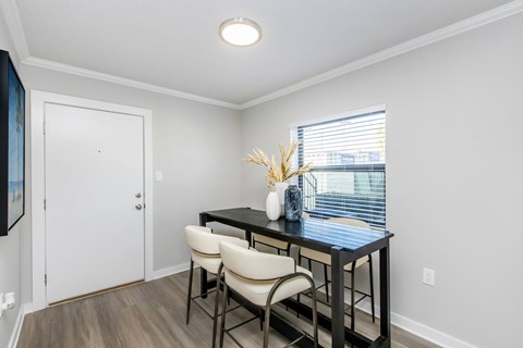 A dining room with a table and chairs.