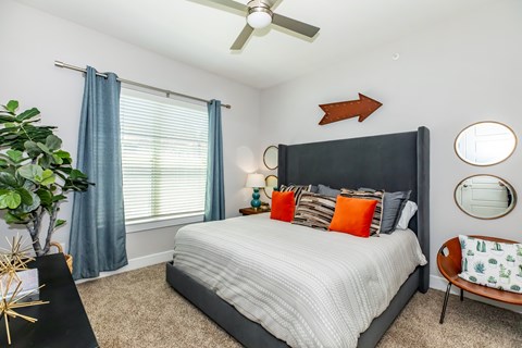 A bedroom with a large bed and a ceiling fan.