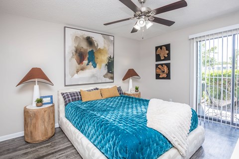 A bedroom with a large bed and a ceiling fan.