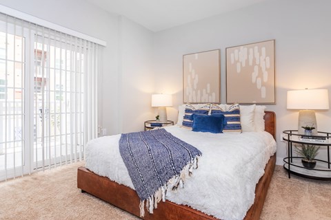 A bedroom with a large bed and two lamps.