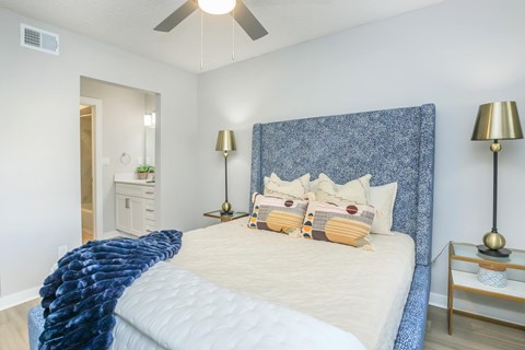 A bedroom with a large bed and a ceiling fan.