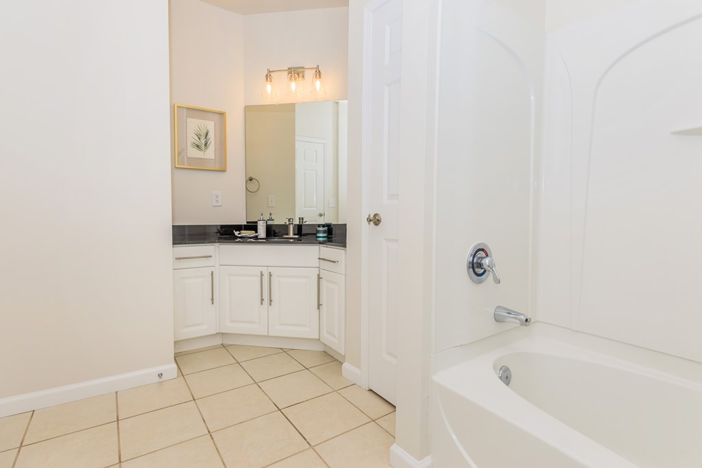 A white bathroom with a tub and sink.