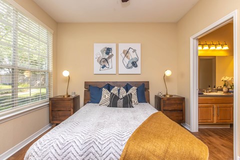 A bedroom with a large bed and two nightstands.