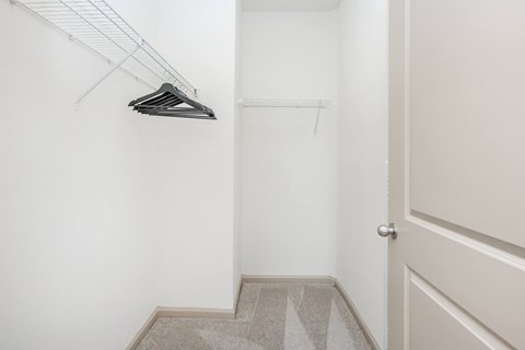 A hallway with a white door and a white wall.