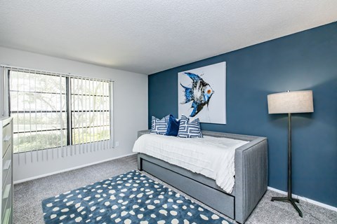 A bedroom with a large bed and a fish picture on the wall.