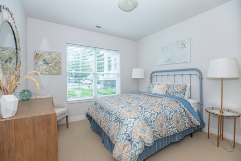 A bedroom with a bed, nightstand, and lamp.