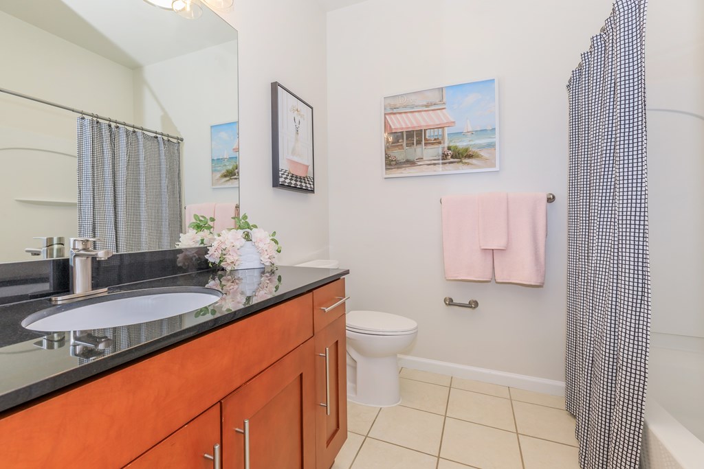 A bathroom with a sink, toilet, and shower.