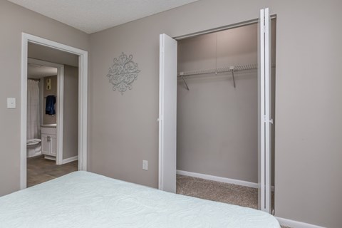 A bedroom with a white bed and a closet with a white door.