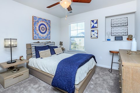A bedroom with a bed, a ceiling fan, and a rug.