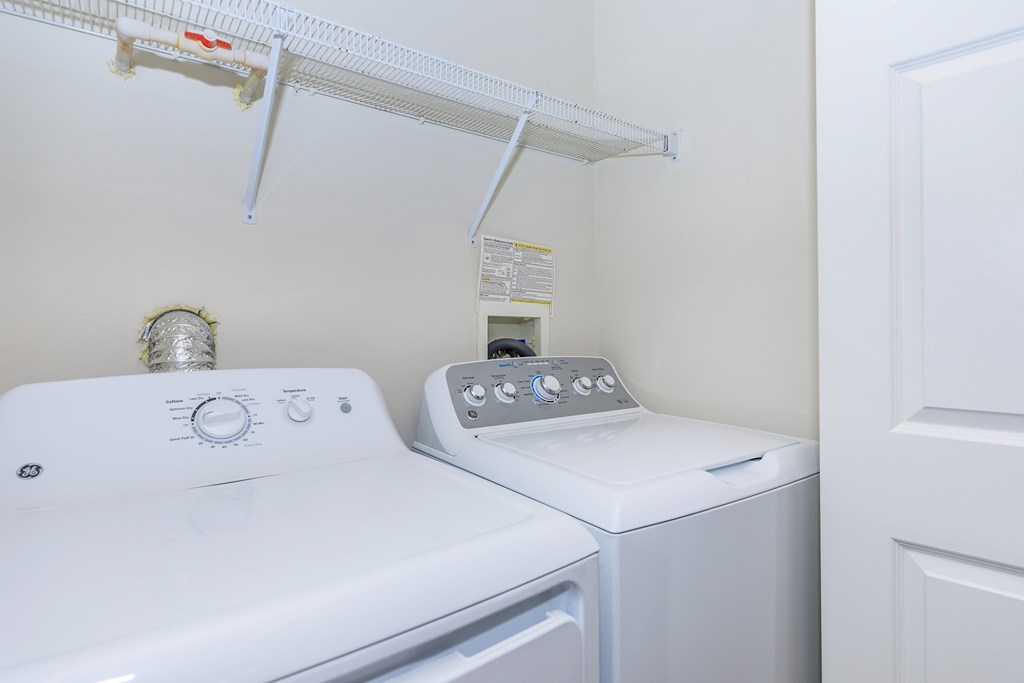 A white dryer and washer in a small laundry room.