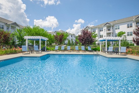 A large swimming pool in front of apartment buildings.
