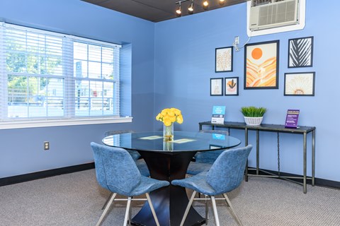 A dining room with a table and chairs.