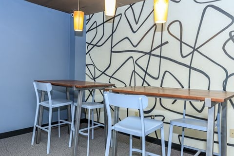 A dining area with a blue wall and a black line drawing on the wall.