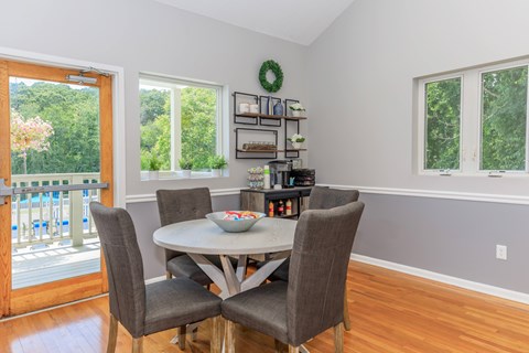A dining room with a table and chairs.
