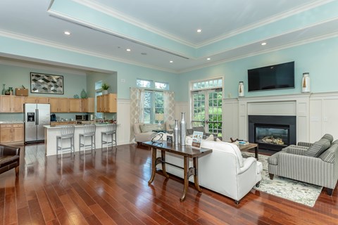 A living room with a fireplace and a television on the wall.