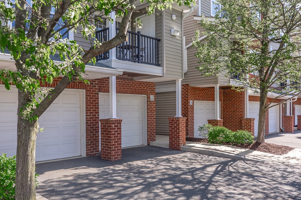 A row of red brick pillars support a white garage door.