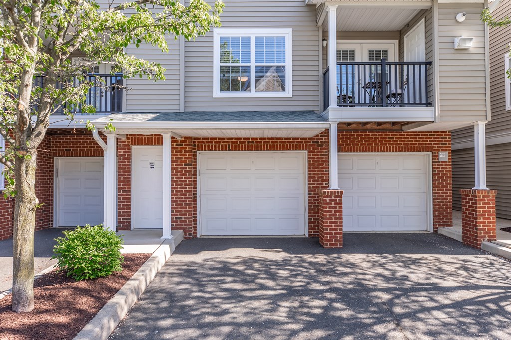 A two-story house with a garage and a balcony.