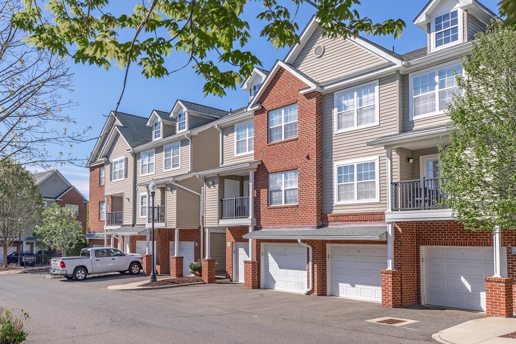 A row of townhouses with a silver truck parked in front.