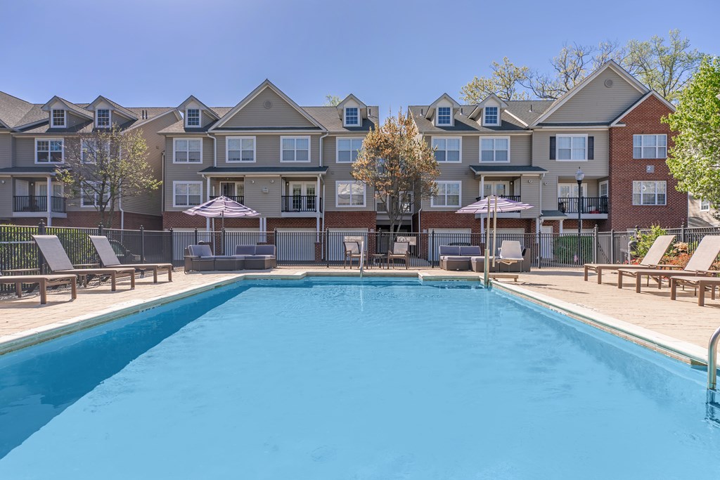 A large swimming pool in front of apartment buildings.