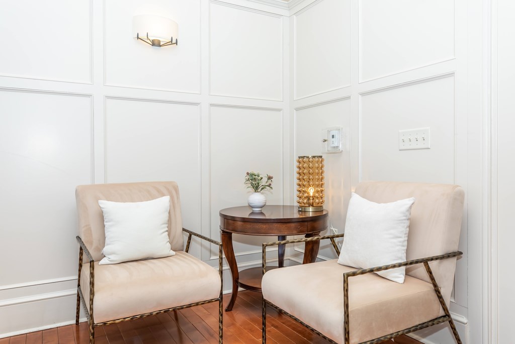 Two chairs and a table with a plant on it.