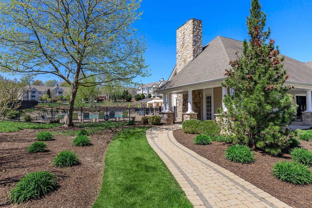 A house with a stone chimney and a landscaped yard.