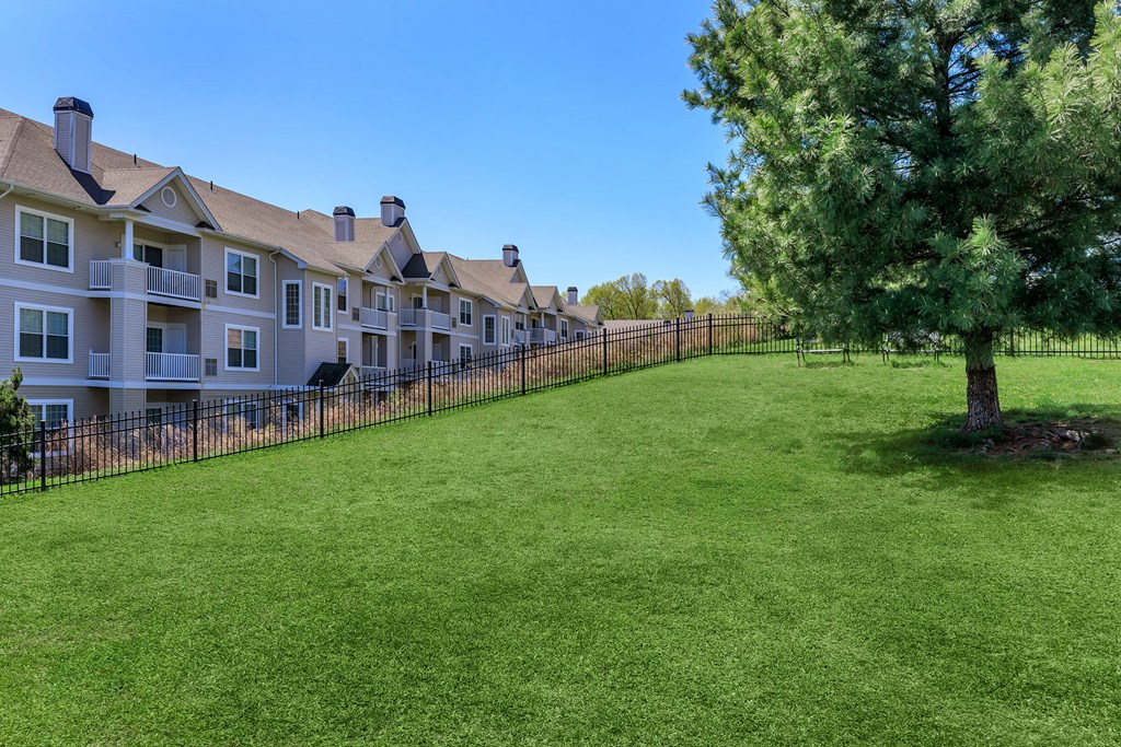 A row of houses with a green lawn in front.