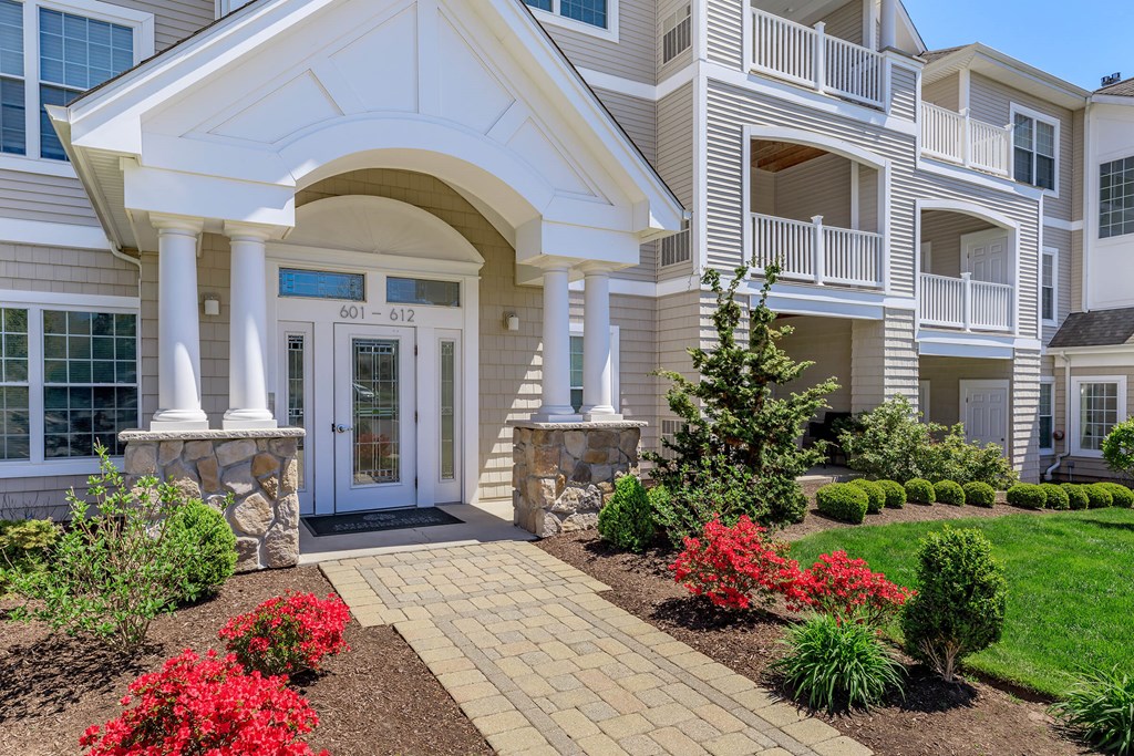 A large house with a white entrance and a stone pillar.