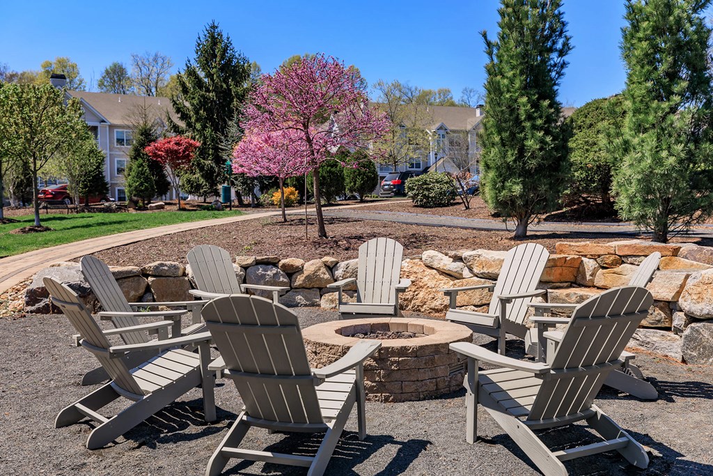 A group of chairs are arranged around a fire pit.