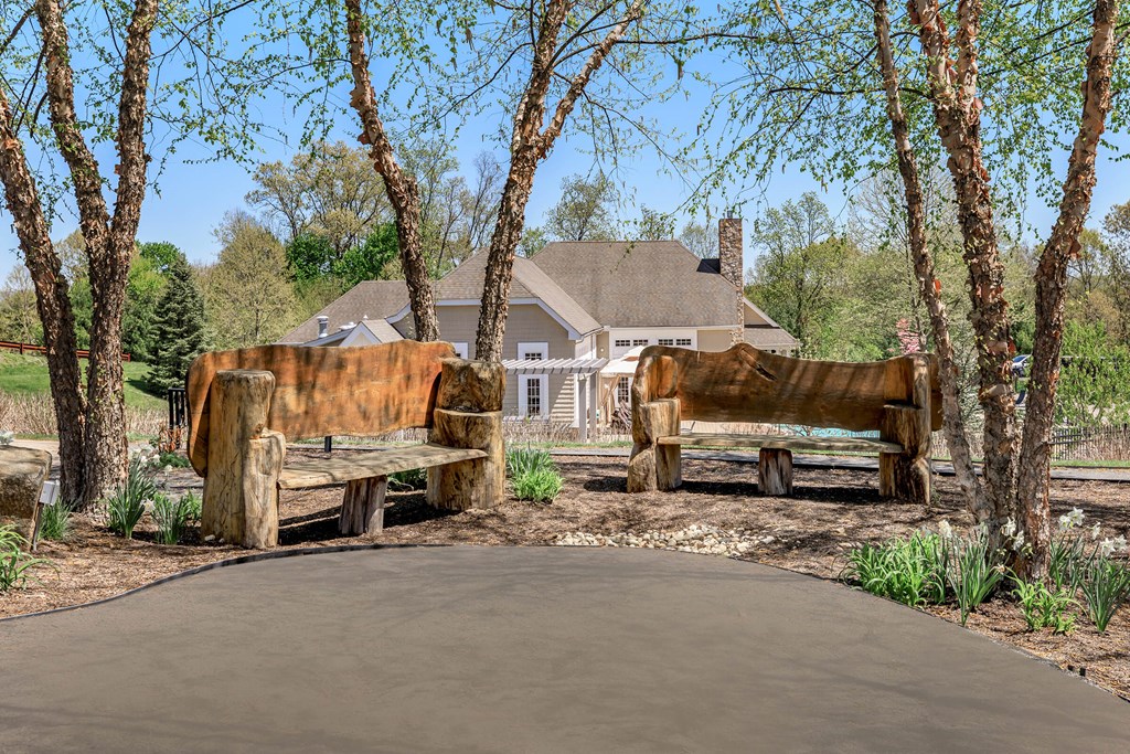 A rusty bench sits in front of a house.