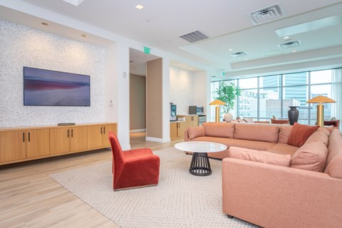 A living room with a red chair and a pink couch.