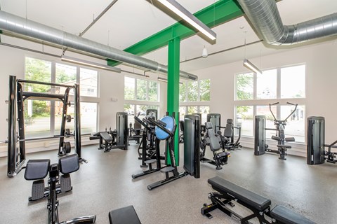 A gym with a variety of equipment including weights and cardio machines.