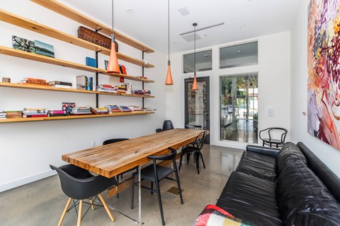 A modern living room with a wooden table and black chairs.